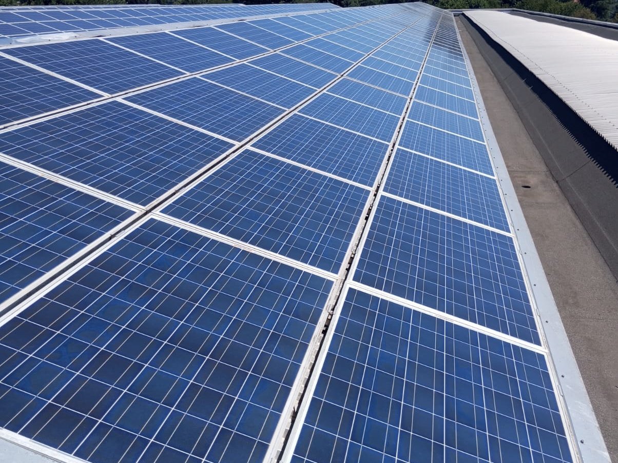 Lavaggio dei moduli fotovoltaici con acqua demineralizzata su una copertura a Como